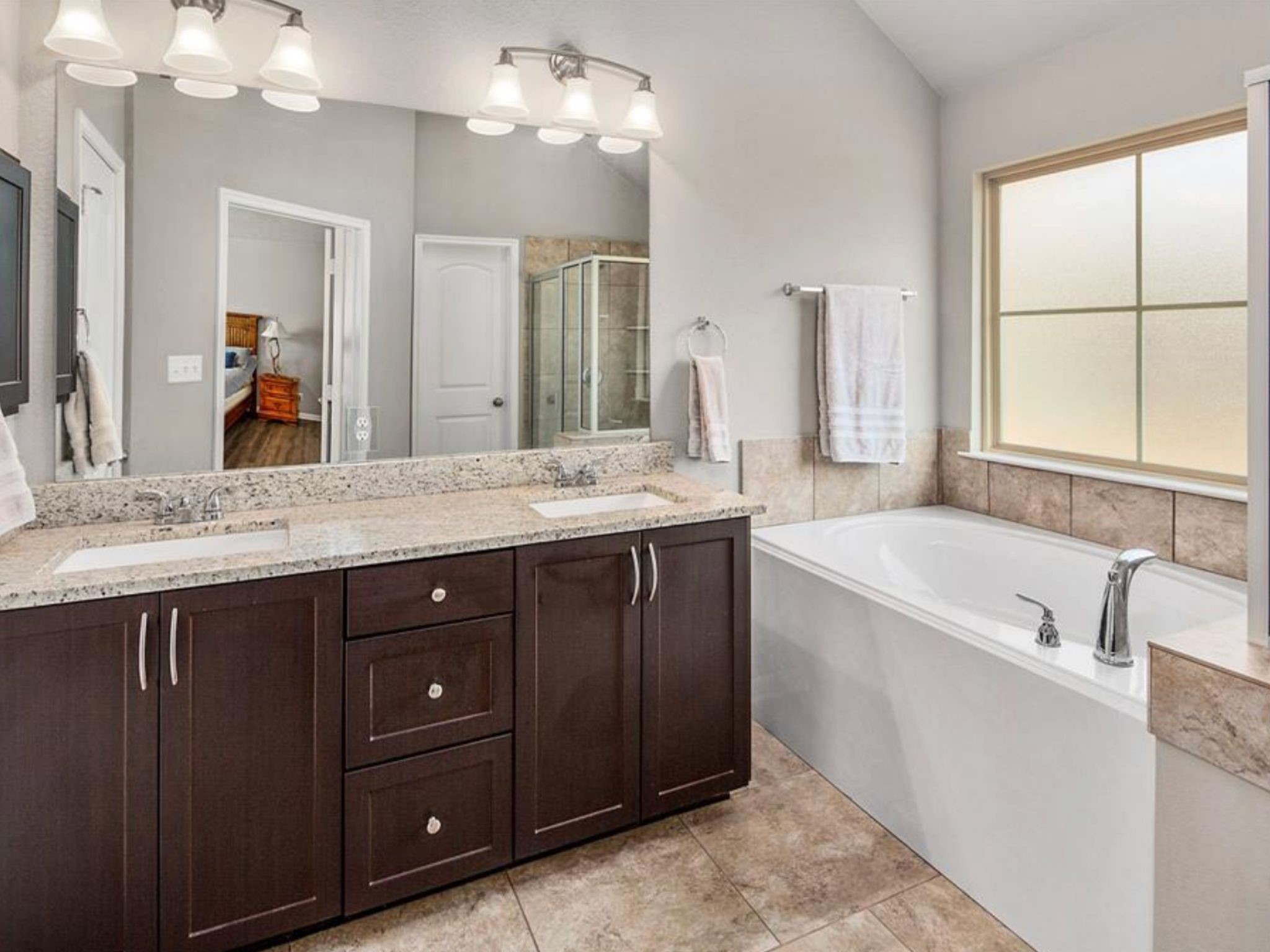 2025 Jester Trail Bryan, TX 77807 - Photo 16 of 24 a spacious bathroom with a tub sink and mirror