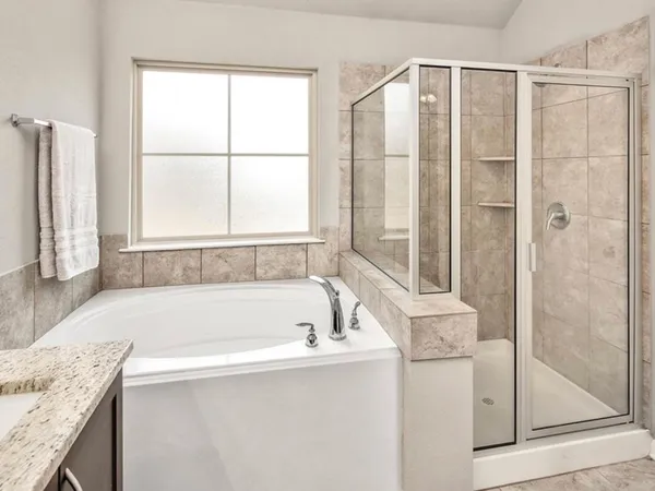 a bathroom with a granite countertop bathtub and a sink