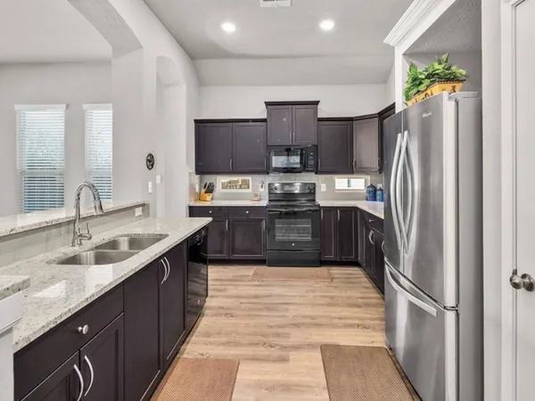 a large kitchen with stainless steel appliances granite countertop a sink counter space and cabinets