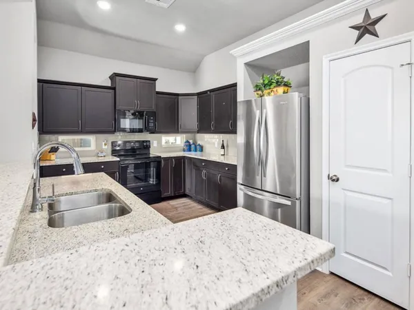 a kitchen with a refrigerator sink and cabinets