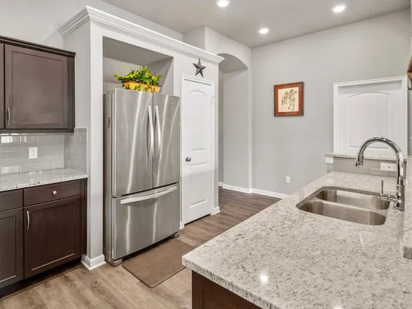 a kitchen with granite countertop a refrigerator and a sink