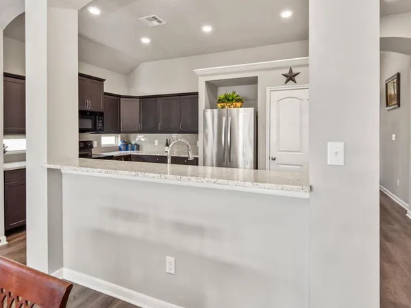 a kitchen with stainless steel appliances granite countertop a refrigerator and a sink