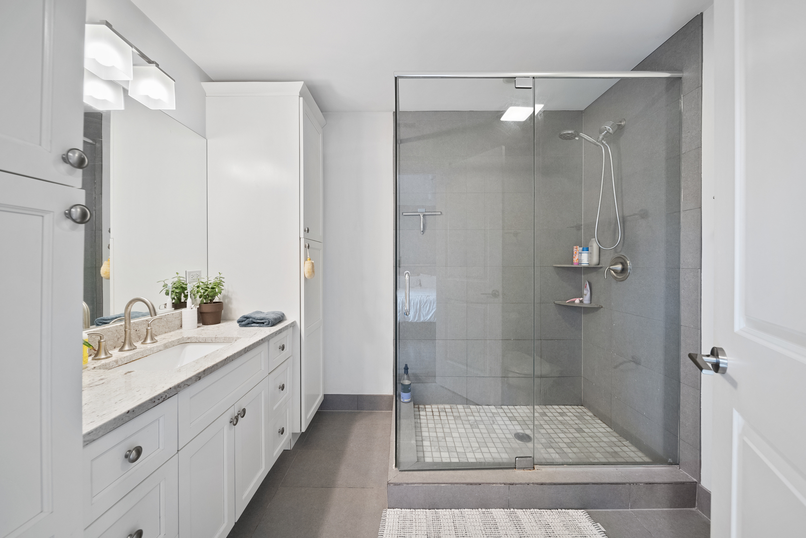 1041 West Madison Street, Unit 3 Chicago, IL 60607 - Photo 19 of 25 a bathroom with a shower sink and mirror