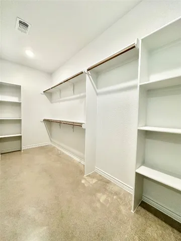 a view of an empty room with closet and a window