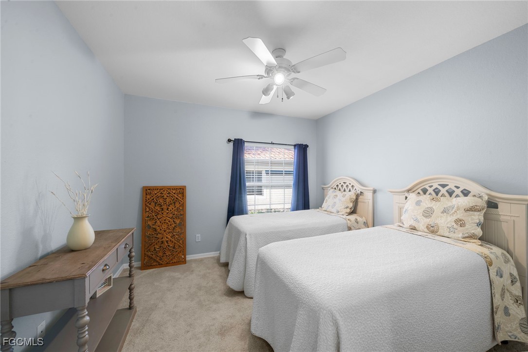 10831 Halfmoon Shoal Road, Unit 104 Estero, FL 34135 - Photo 23 of 49 a bedroom with two beds and a chandelier