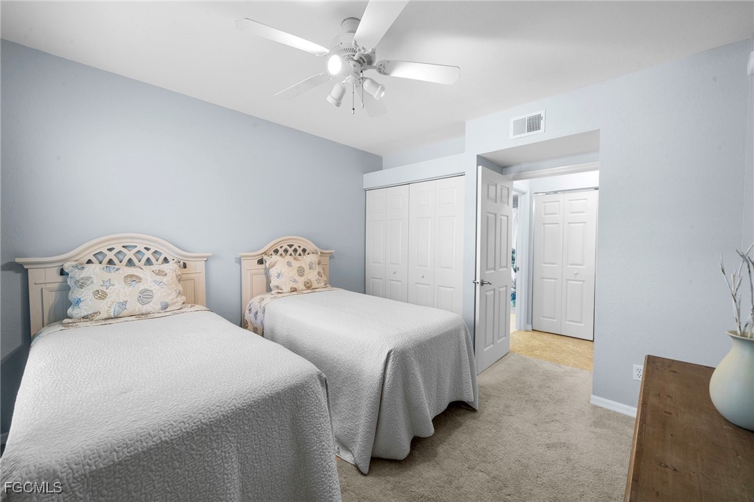 10831 Halfmoon Shoal Road, Unit 104 Estero, FL 34135 - Photo 24 of 49 a bedroom with two beds and a chandelier