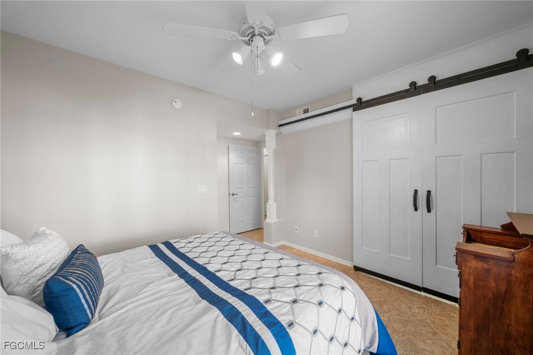 10831 Halfmoon Shoal Road, Unit 104 Estero, FL 34135 - Photo 27 of 49 a bedroom with a bed and a ceiling fan