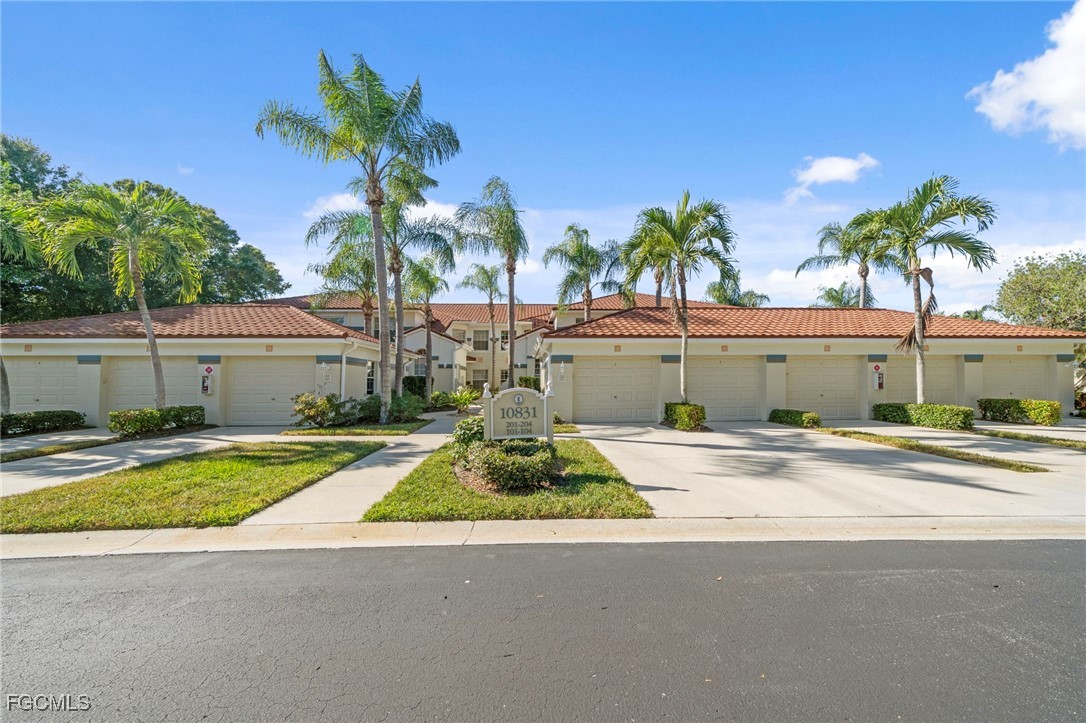 10831 Halfmoon Shoal Road, Unit 104 Estero, FL 34135 - Photo 38 of 49 a front view of house with yard and car parked
