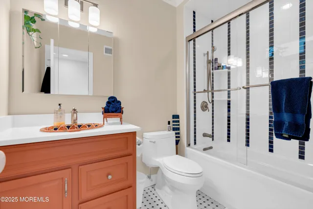 a bathroom with a sink toilet a mirror a vanity and shower