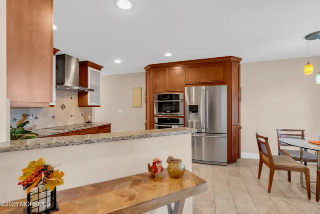 a kitchen with stainless steel appliances granite countertop a refrigerator and a sink