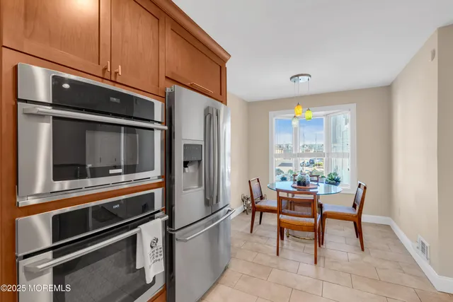 a kitchen with stainless steel appliances kitchen island granite countertop a refrigerator and a stove top oven