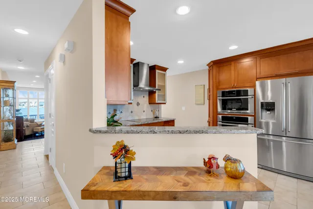 a kitchen with stainless steel appliances granite countertop a refrigerator and a sink