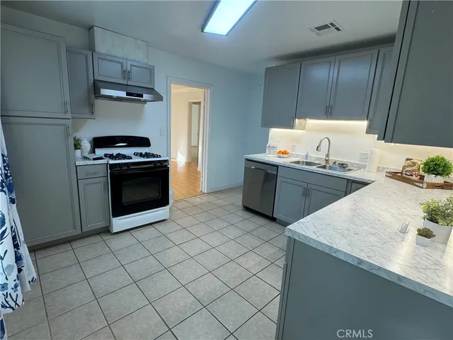 a kitchen with stainless steel appliances a sink stove and refrigerator
