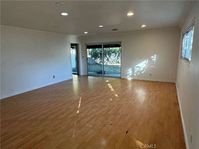 an empty room with stairs and wooden floor
