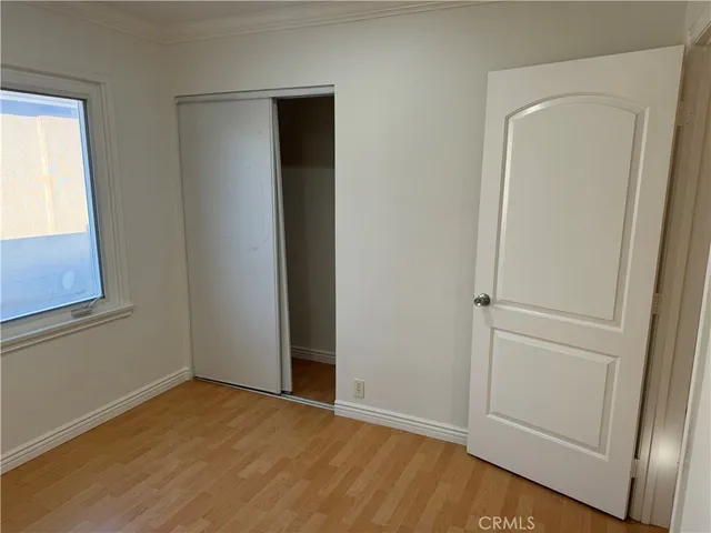 an empty room with wooden floor and closet
