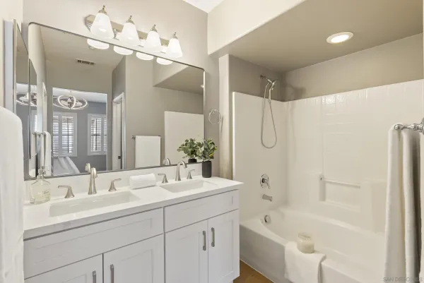 a bathroom with a tub sink and mirror