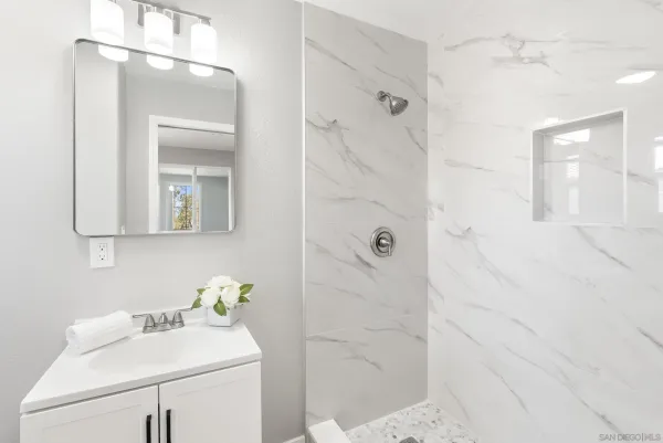 a bathroom with a sink a toilet and shower