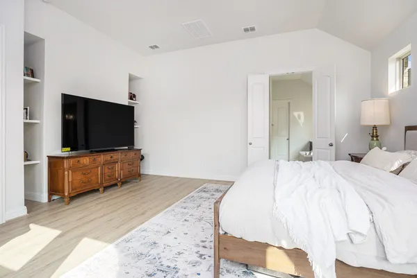 a bedroom with a bed and a flat screen tv