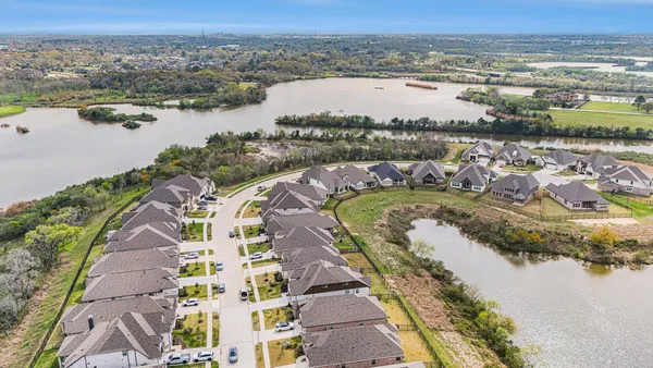 an aerial view of residential houses with outdoor space and swimming pool