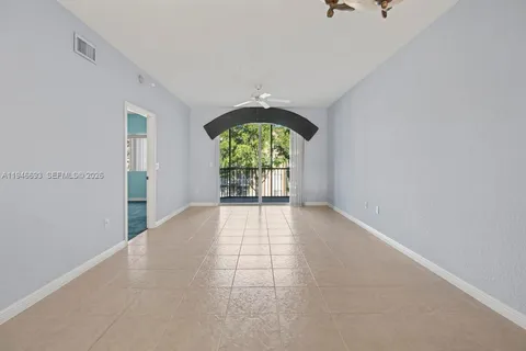 an empty room with fan and entrance