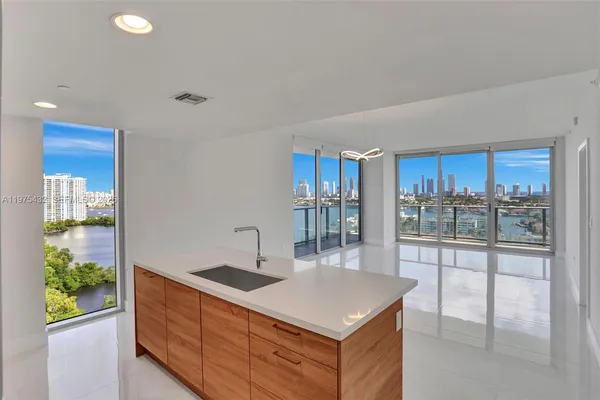a kitchen with stainless steel appliances a sink and a wooden floor