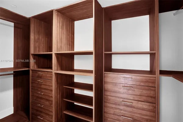 a view of walk in closet with empty racks