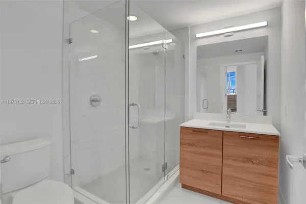 a bathroom with a shower sink vanity and mirror