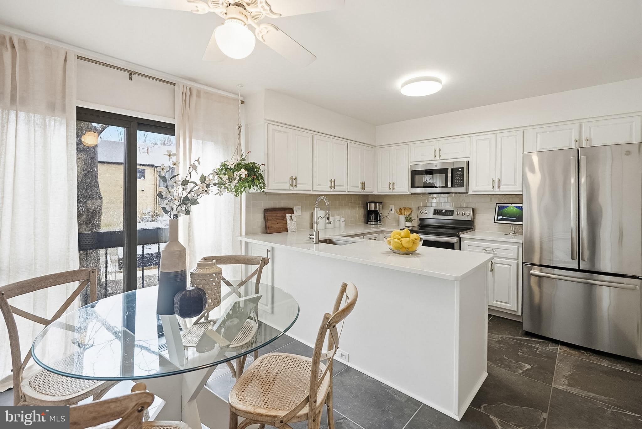 9060 Blarney Stone Drive Springfield, VA 22152 - Photo 12 of 47 a kitchen with stainless steel appliances a dining table chairs and refrigerator