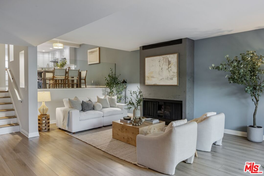 a living room with furniture a fireplace and potted plants