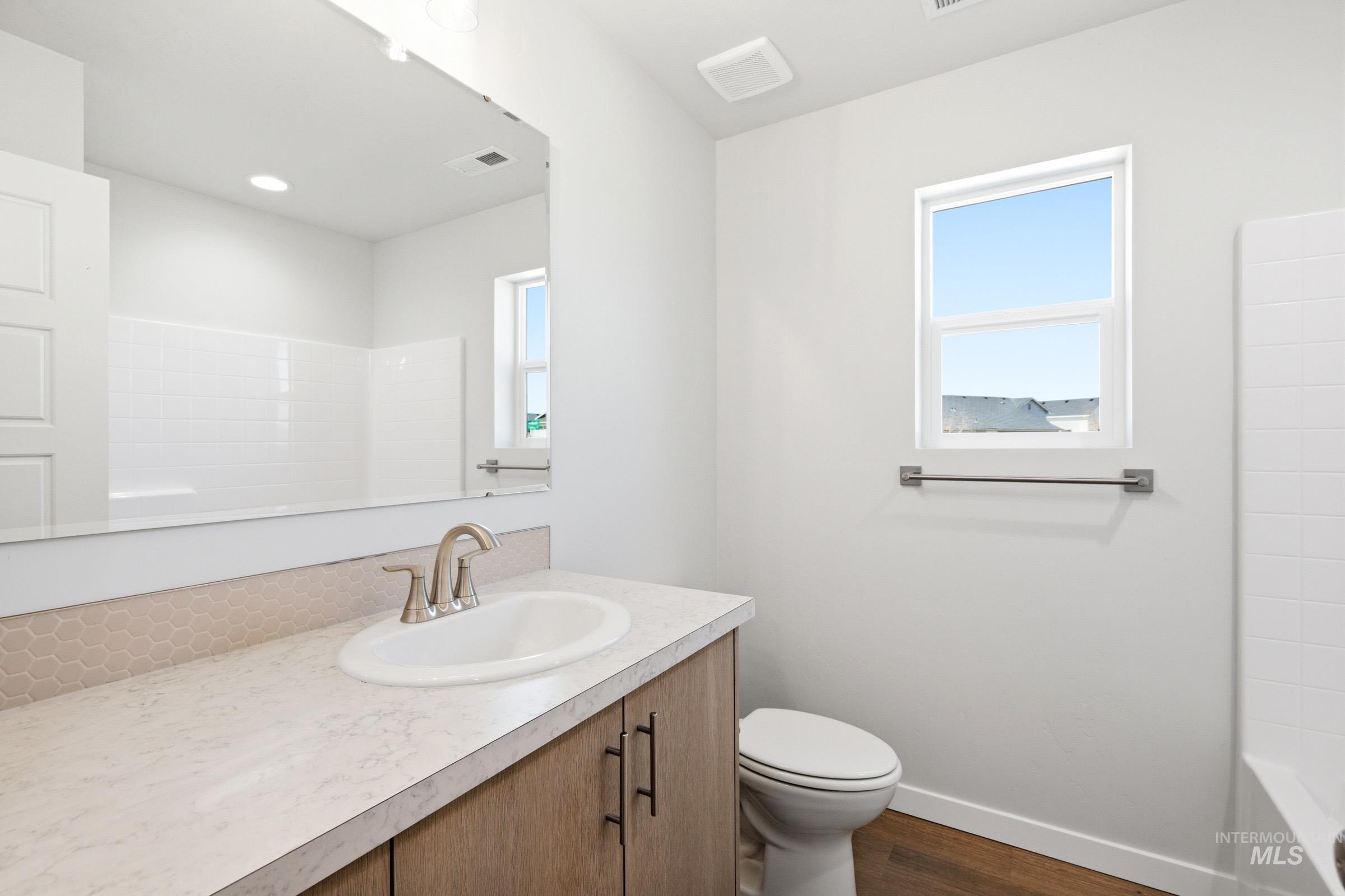 12877 Decatur Street Nampa, ID 83651 - Photo 18 of 22 Bathroom featuring a single vanity with an integrated sink, light-toned countertop, and wood-finish cabinetry
