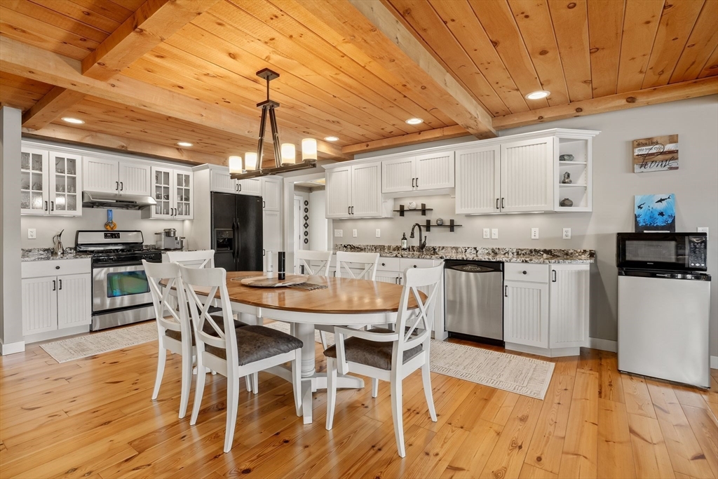 22 Pattison Road Webster, MA 01570 - Photo 12 of 42 a kitchen with stainless steel appliances kitchen island granite countertop a table chairs stove and white cabinets