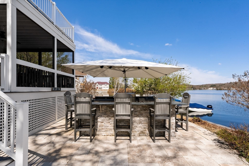 22 Pattison Road Webster, MA 01570 - Photo 33 of 42 a view of a patio with a table and chairs under an umbrella