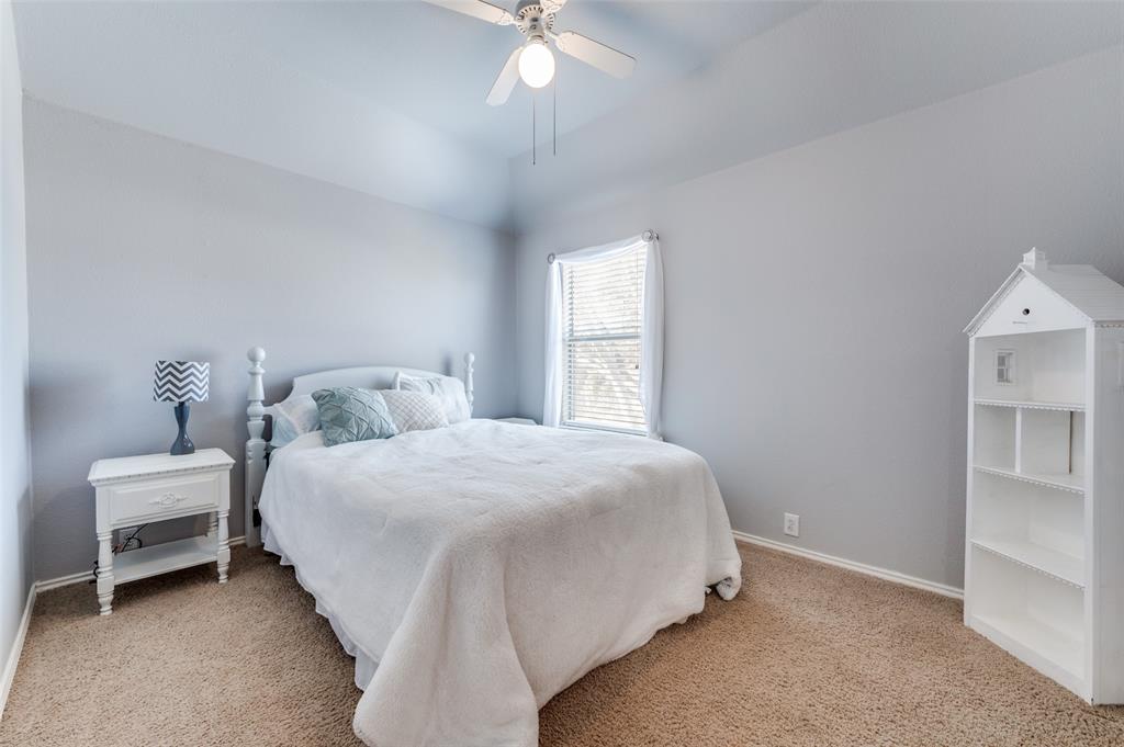 5904 Berkshire Road McKinney, TX 75072 - Photo 12 of 26 a bedroom with a bed and a chandelier