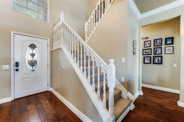 a view of front door with wooden floor and stairs