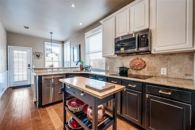 a kitchen with stainless steel appliances granite countertop a sink stove and microwave