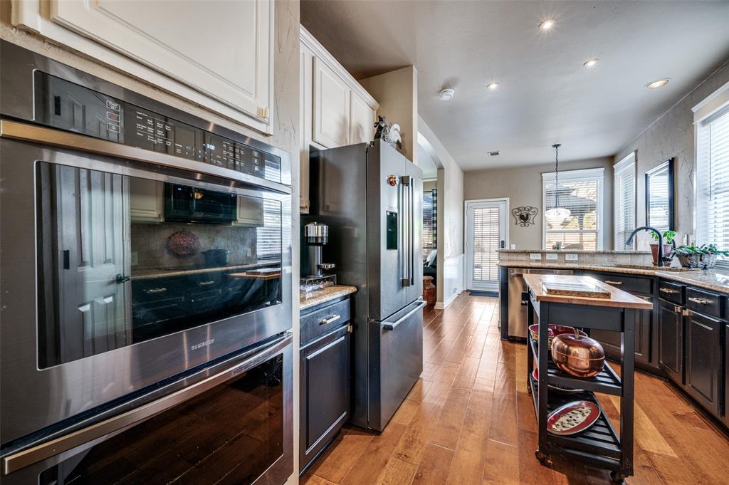 5904 Berkshire Road McKinney, TX 75072 - Photo 5 of 26 a kitchen with stainless steel appliances kitchen island granite countertop a refrigerator and a stove top oven