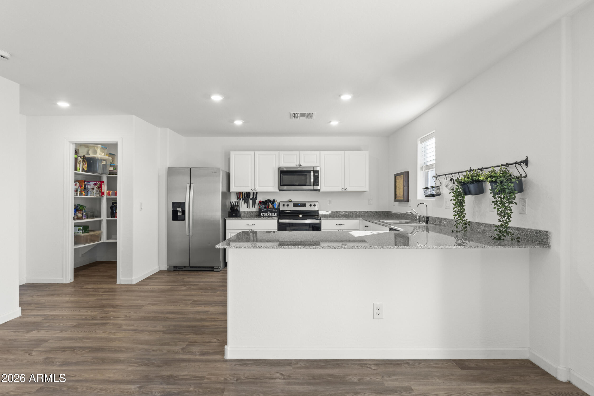 83 South Naples Lane Casa Grande, AZ 85122 - Photo 11 of 26 a kitchen with stainless steel appliances granite countertop a refrigerator a stove and a wooden floors