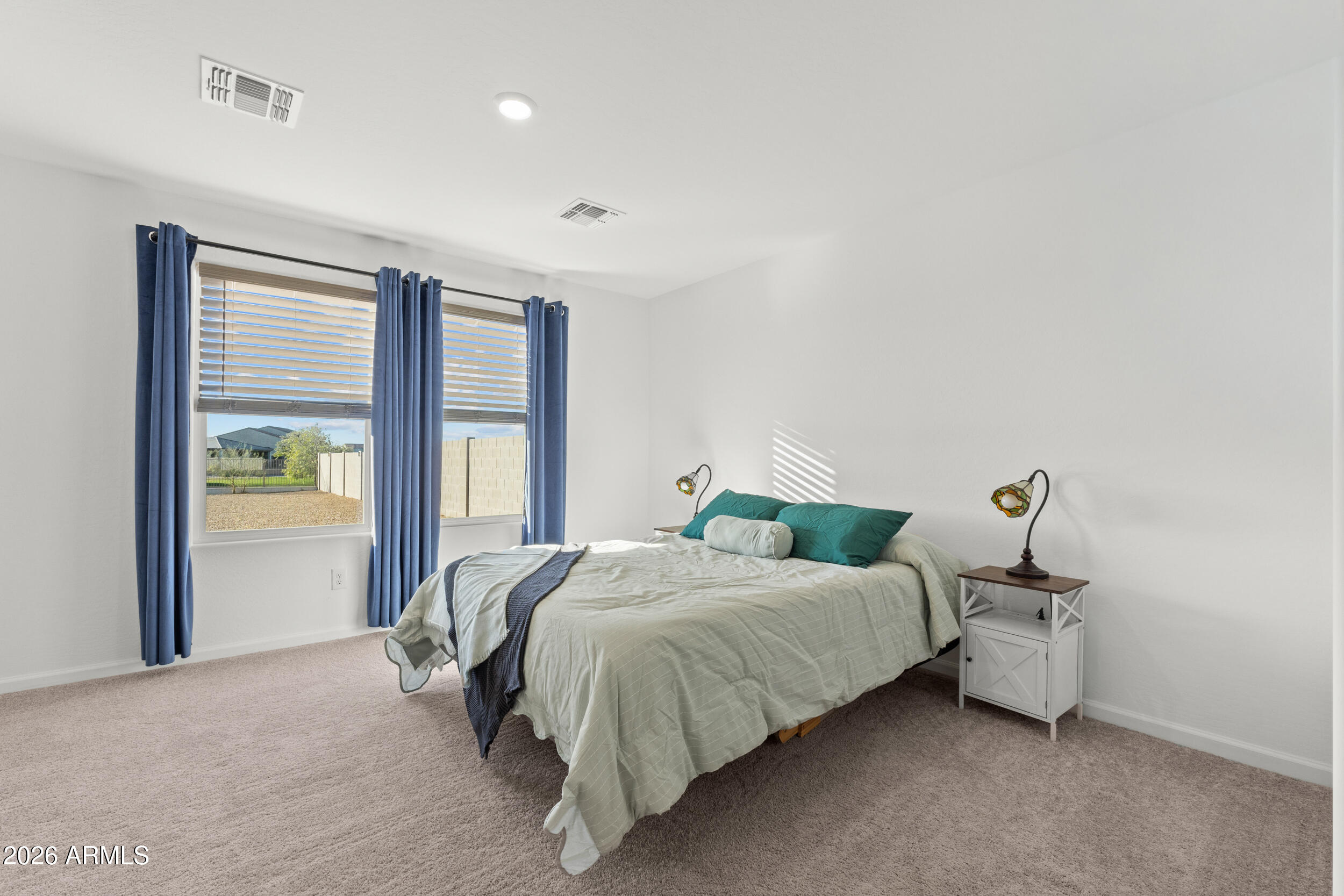 83 South Naples Lane Casa Grande, AZ 85122 - Photo 20 of 26 a bedroom with a bed and large windows