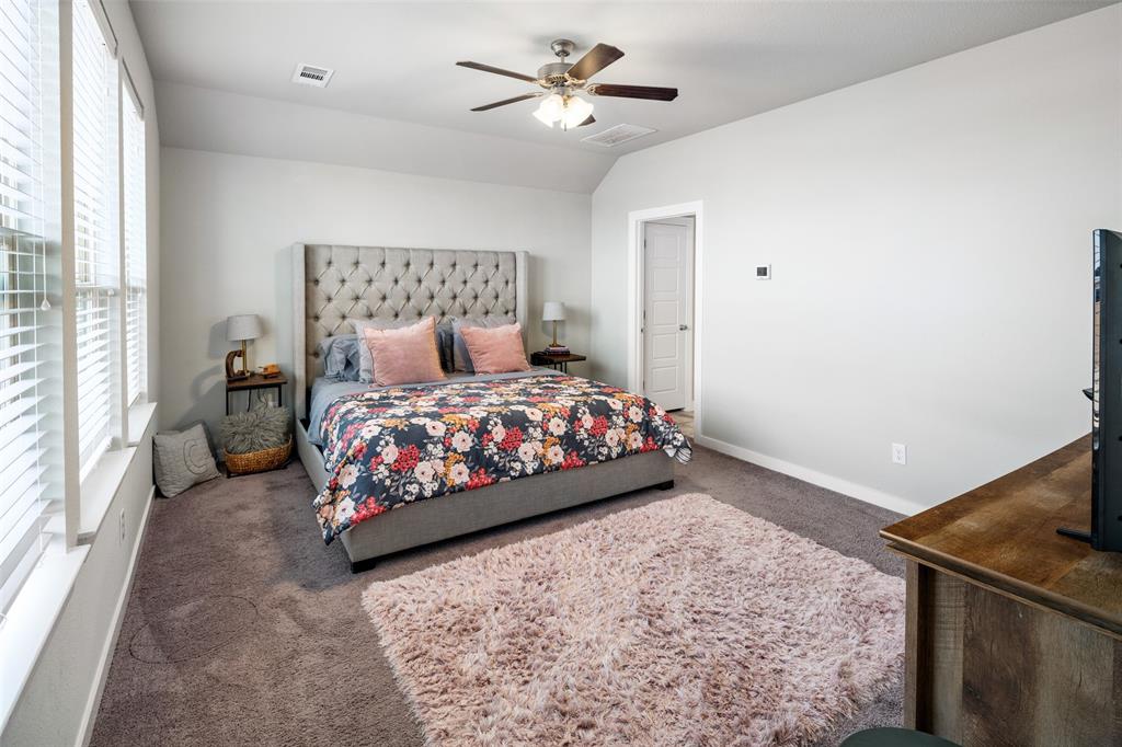 4209 Switchgrass Street Celina, TX 75009 - Photo 11 of 18 a bedroom with a bed and a chandelier