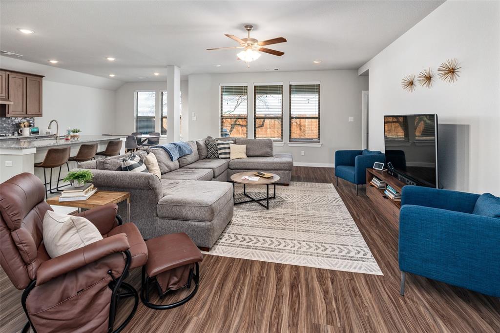 4209 Switchgrass Street Celina, TX 75009 - Photo 5 of 18 a living room with furniture a flat screen tv and kitchen view