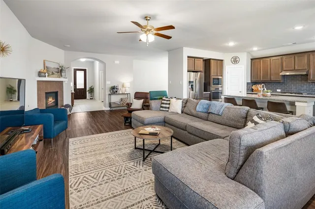 a living room with furniture kitchen view and a chandelier