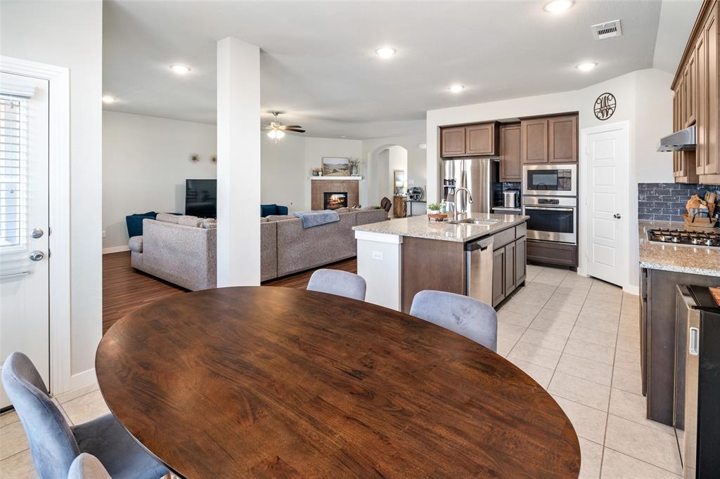4209 Switchgrass Street Celina, TX 75009 - Photo 8 of 18 a living room with kitchen island furniture and a wooden floor