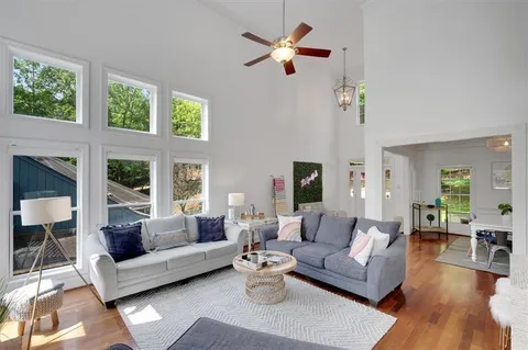 a living room with furniture ceiling fan and a window