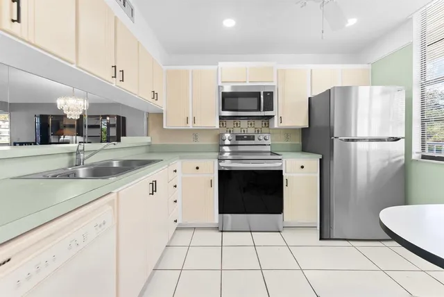 a kitchen with stainless steel appliances a refrigerator sink and microwave