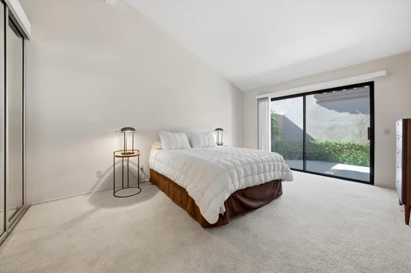 a spacious bedroom with a bed and a large window