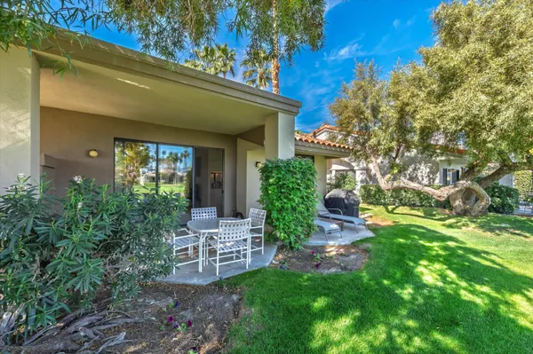 a view of a house with a yard and sitting area