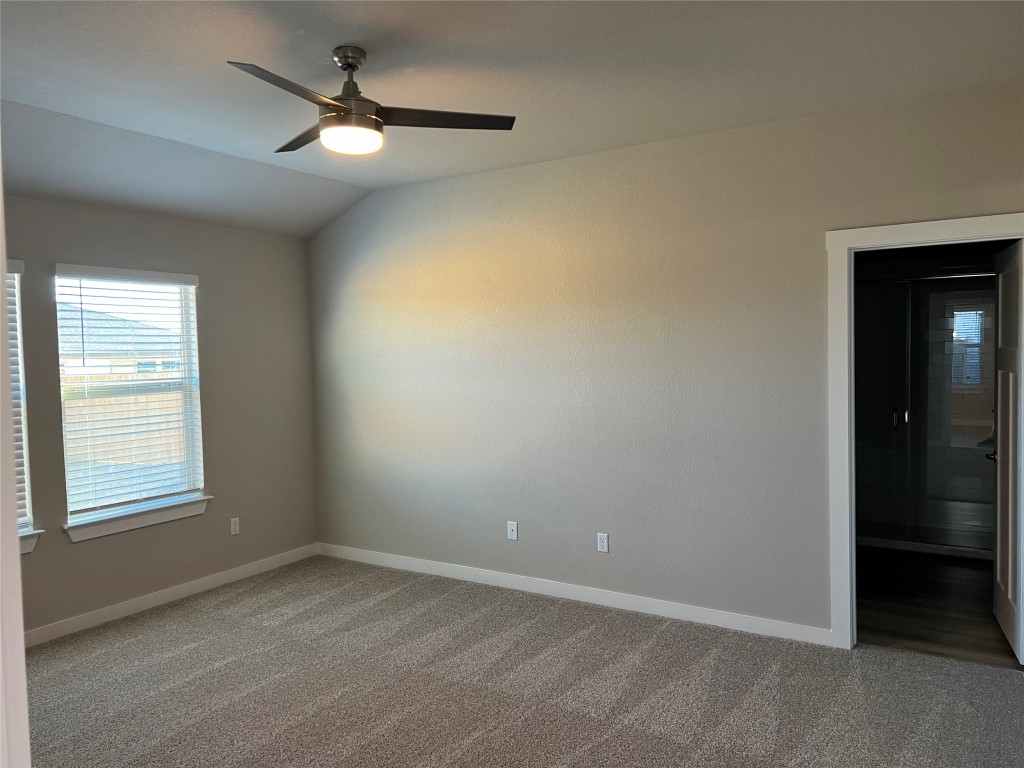 404 Coda Crossing Georgetown, TX 78633 - Photo 5 of 15 Unfurnished room featuring light carpet, lofted ceiling, and ceiling fan