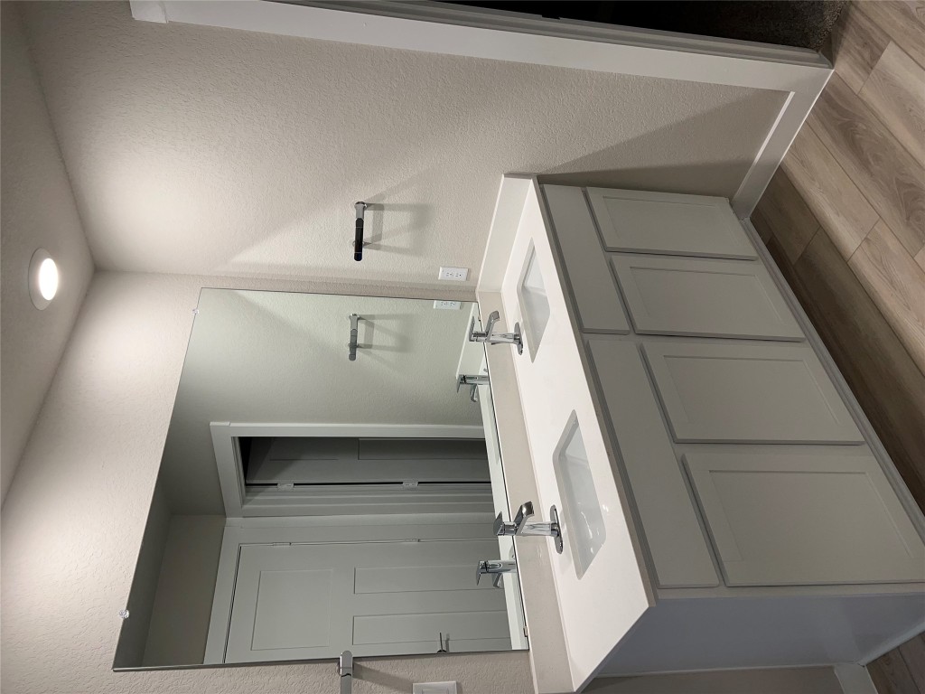 404 Coda Crossing Georgetown, TX 78633 - Photo 8 of 15 Full bath with a textured wall, double vanity, and light wood-type flooring