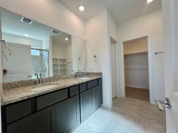 a bathroom with a granite countertop sink double and mirror