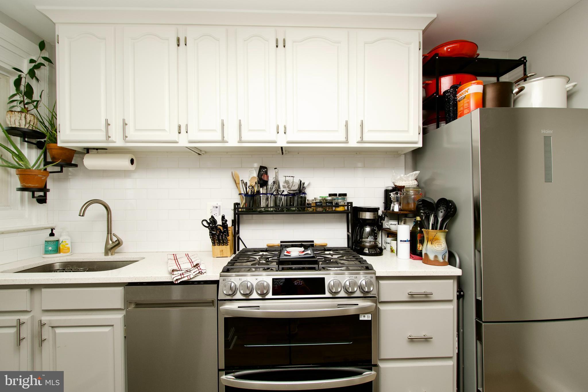 1702 Lang Place Northeast Washington, DC 20002 - Photo 12 of 36 a kitchen with stainless steel appliances granite countertop a stove and a refrigerator